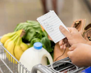 A hand holding a grocery list