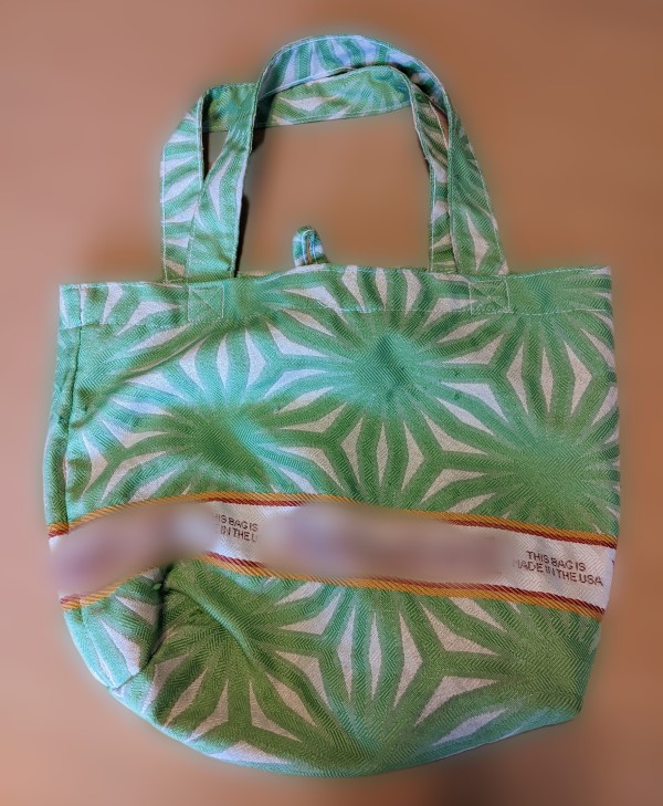A green and white woven carrier bag with made in the usa print
