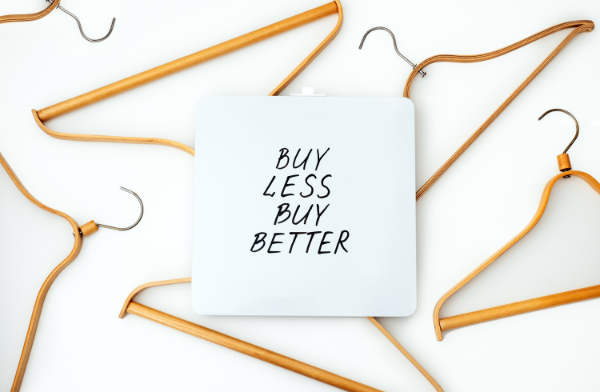 coat hangers with a sign saying buy less, buy better